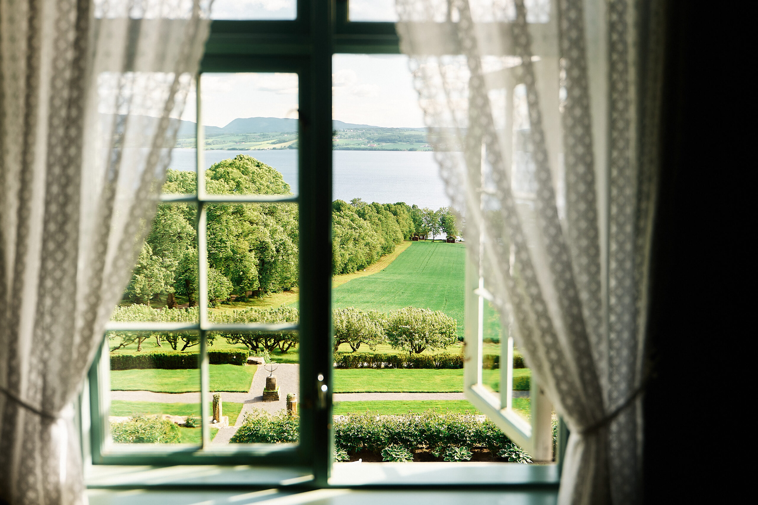 Utsikt fra et vindu på Hoel gård ved Mjøsa.