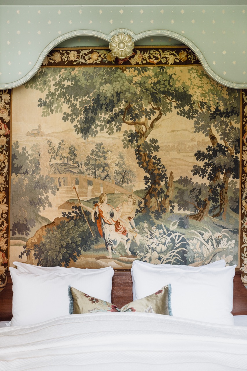 Himmelseng i grønne farger med landskapsbilde bak sengegavlen på hotell Union Øye.